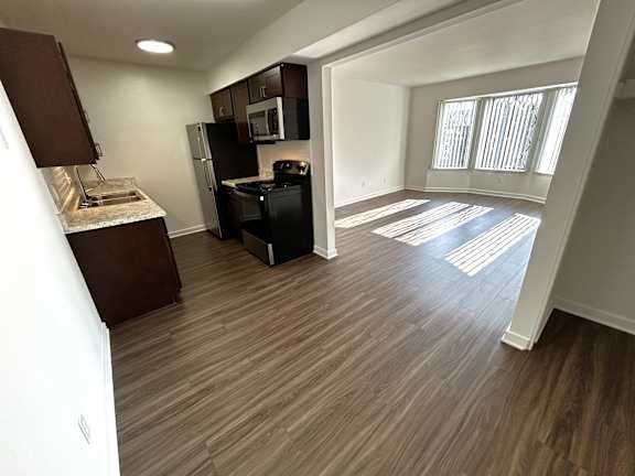 Open floor plan with kitchen and sunlit living area at Charter Oaks Apartments, Davison