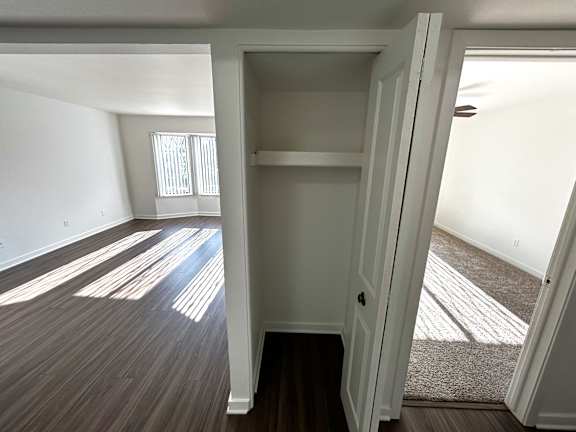 Open closet and connecting rooms with wood flooring at Charter Oaks Apartments, Davison