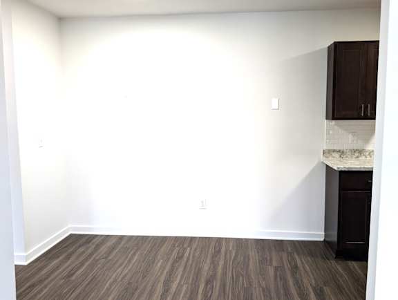Empty room with dark wood cabinets and granite countertop at Charter Oaks Apartments, Michigan, 48423