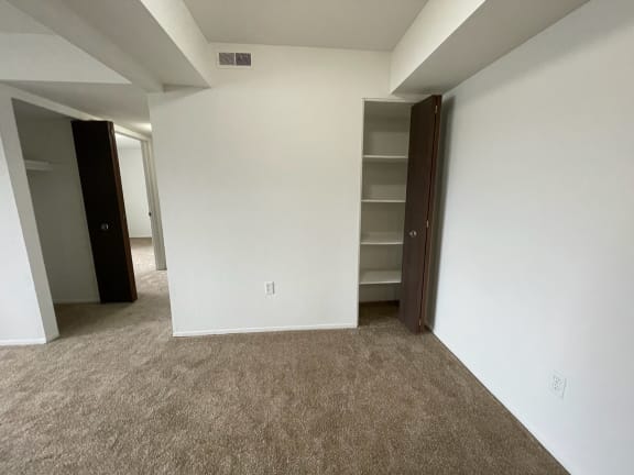 Empty carpeted room with closet and connecting hallway at Charter Oaks Apartments, Davison, MI