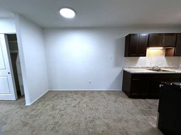 Basement studio with kitchenette and ceiling light at Charter Oaks Apartments, Davison, Michigan