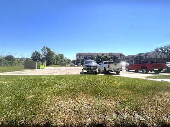 Parking lot with trucks and apartment buildings at Charter Oaks Apartments, Davison, Michigan