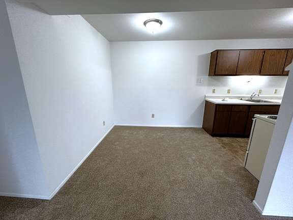 Open floor plan with kitchenette and carpeted space 1 at Charter Oaks Apartments, Michigan