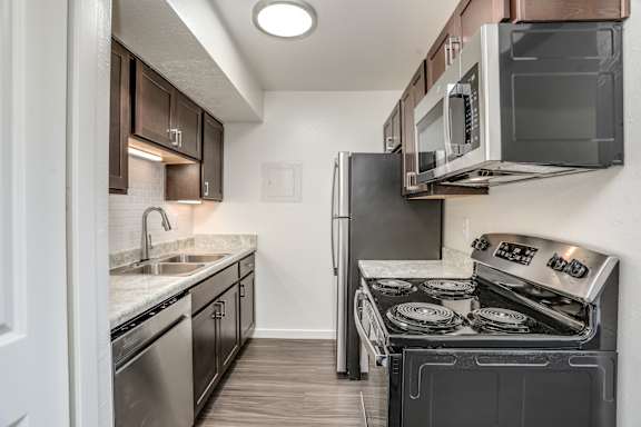 A kitchen with a black stove top oven and a black refrigerator.