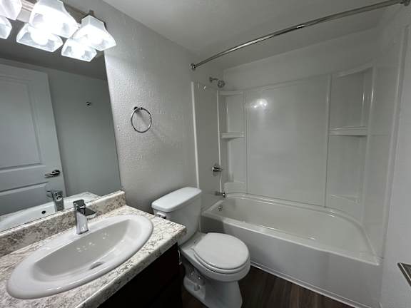 A white bathroom with a sink, toilet, and bathtub.