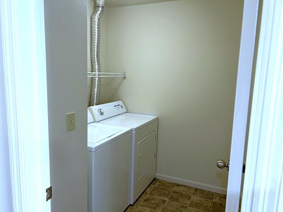 A white washer and dryer in a small room.