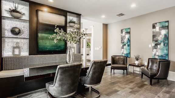 A living room with a grey sofa and a glass display cabinet.