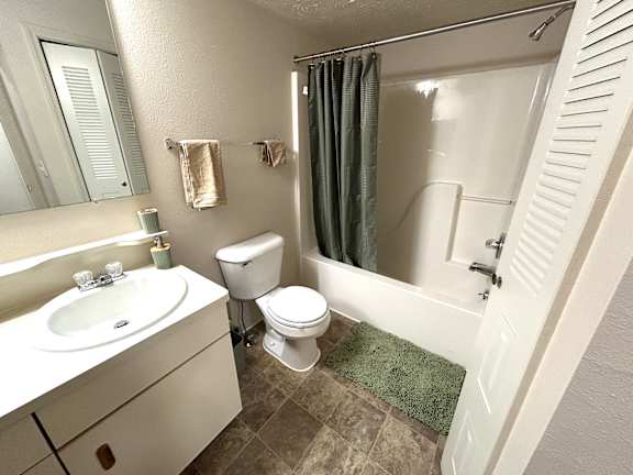 A bathroom with a toilet, sink, and shower.