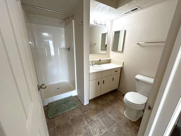 A bathroom with a toilet, sink, and shower.
