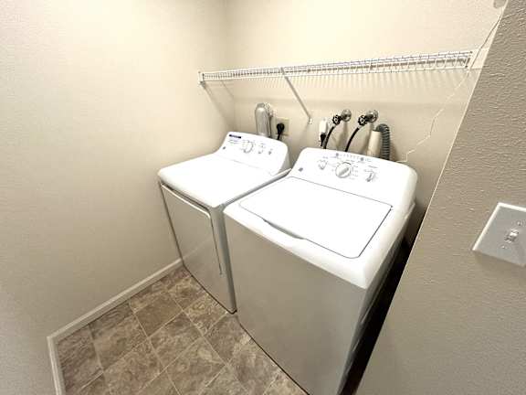 A white washing machine is sitting in a laundry room.