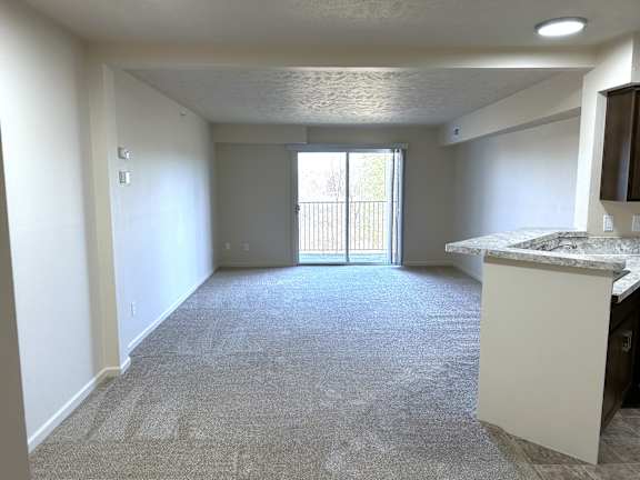 Open living room with patio balcony access at Heatherwood Apartments, Grand Blanc, 48439