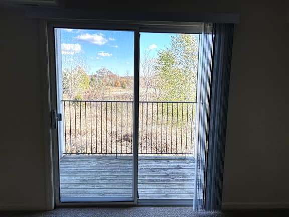 Wooden deck balcony overlooking autumn trees and hills at Heatherwood Apartments, Grand Blanc, MI
