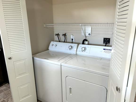 Washer and dryer with overhead shelving at Heatherwood Apartments, Grand Blanc, Michigan
