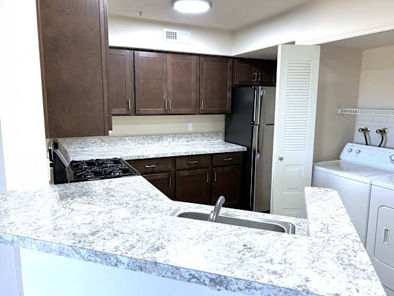 Kitchen island with granite countertop and undermount sink at Heatherwood Apartments, Grand Blanc