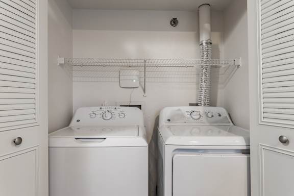 A laundry closet with a washer and dryer