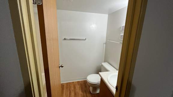 Bathroom with toilet shower and wood style flooring at Charter Oaks Apartments, Davison, MI, 48423