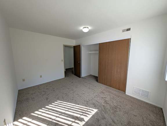 Carpeted bedroom with built in closet and doorway at Charter Oaks Apartments, Davison, MI