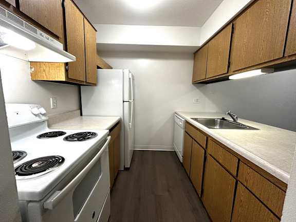Galley kitchen with electric coil stove and refrigerator 1 at Charter Oaks Apartments, Michigan