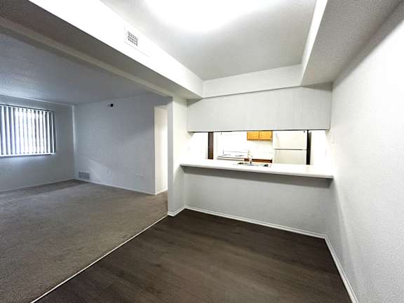 Open living area with kitchen passthrough window at Charter Oaks Apartments, Davison, MI
