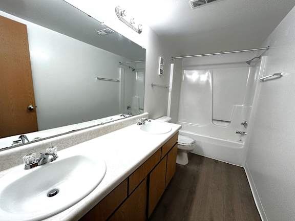 Double vanity bathroom with tub shower combo at Charter Oaks Apartments, Davison, Michigan