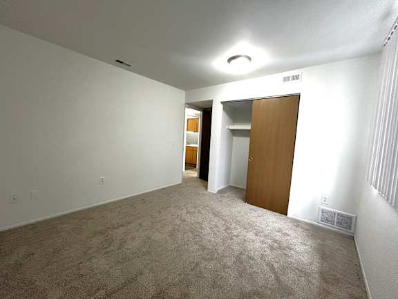 Carpeted bedroom with open closet and hallway view 1 at Charter Oaks Apartments, Davison