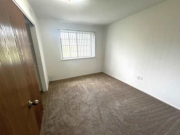 Empty bedroom with window and carpet flooring at Charter Oaks Apartments, Davison, Michigan