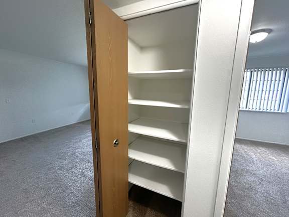Walk-in closet with multiple white shelves at Charter Oaks Apartments, Davison, MI, 48423