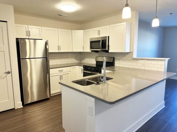 a kitchen with white cabinets and stainless steel appliances  at Signature Pointe Apartment Homes, Athens, 35611