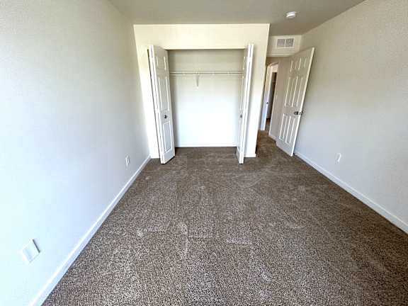 A 2nd bedroom  room with carpeted floor and white walls.
