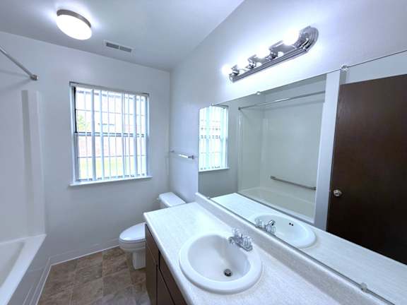 A bathroom with a white sink and a window.