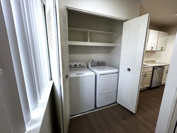 An in-unit laundry with a washer and dryer.