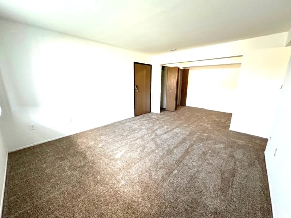 Spacious carpeted room with multiple doorways and natural light at Charter Oaks Apartments, Davison