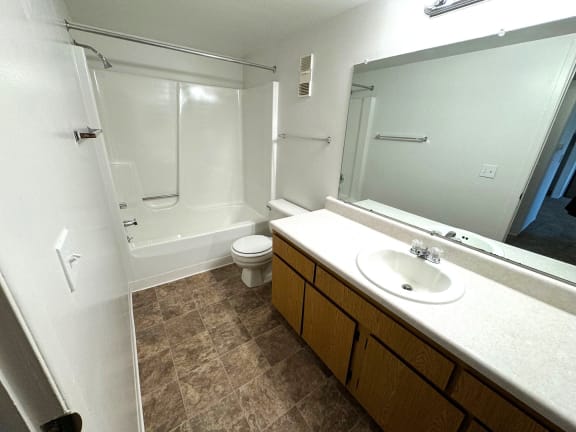 Full bathroom with vanity and tub shower combination at Charter Oaks Apartments, Michigan