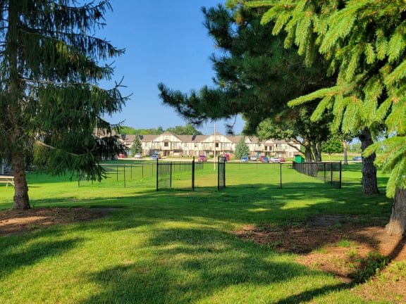 a large grassy area with trees in the foreground and houses in the background at Beacon Hill and Great Oaks Apartments, Illinois, 61109