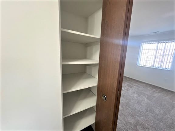 Builtin shelving with wooden closet door at Charter Oaks Apartments, Michigan