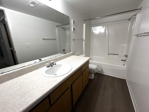 Bathroom with wood vanity and dark flooring at Charter Oaks Apartments, Davison, 48423