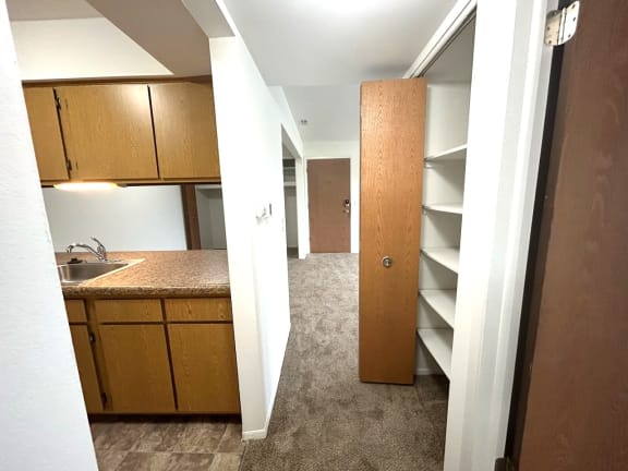 Kitchenette with storage closet and built in shelving at Charter Oaks Apartments, Michigan