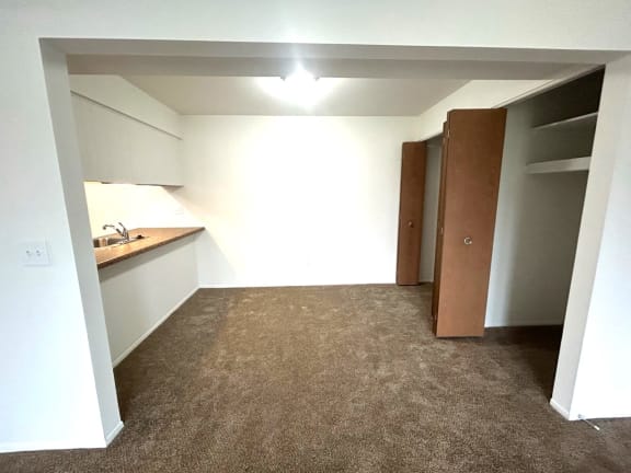 Studio with kitchenette alcove and closet storage at Charter Oaks Apartments, Davison, MI