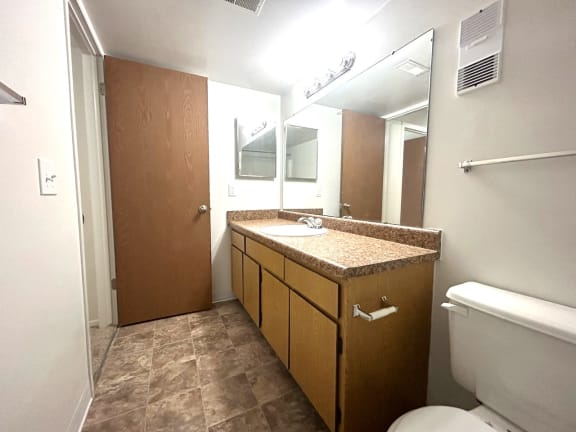 Bathroom with granite vanity and tiled flooring at Charter Oaks Apartments, Davison, MI