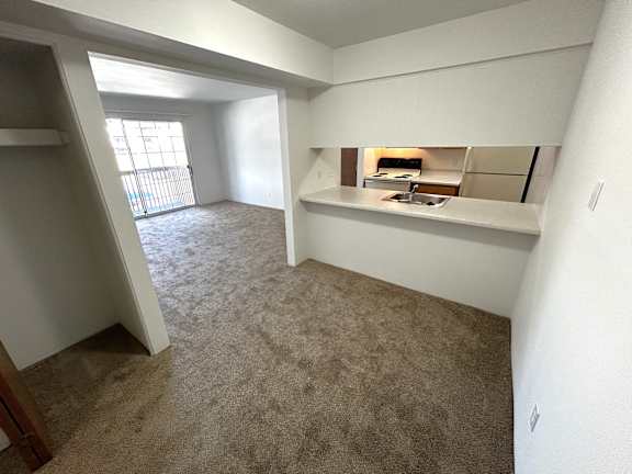 A dining room with a carpeted floor and a window.