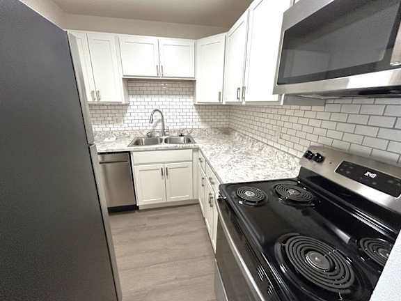 A kitchen with a black stove top oven and white cabinets.