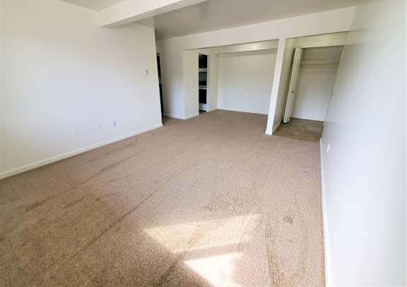 A living room with carpeted floor and white walls.