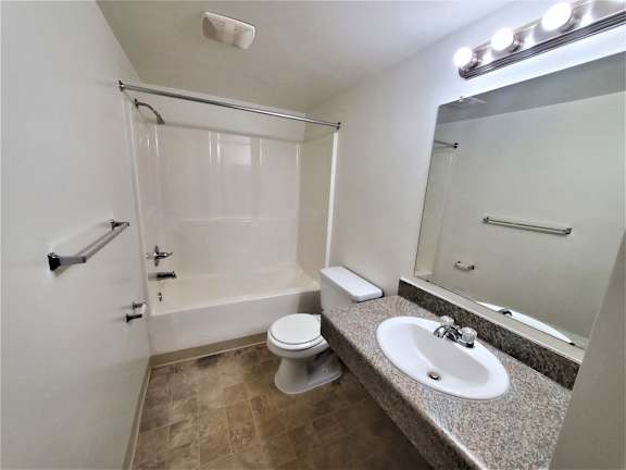 A bathroom with a toilet, sink, and shower.