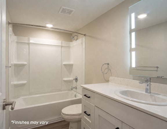 A white bathroom with a toilet, sink, and bathtub.