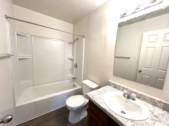 A white bathroom with a toilet, sink, and bathtub.