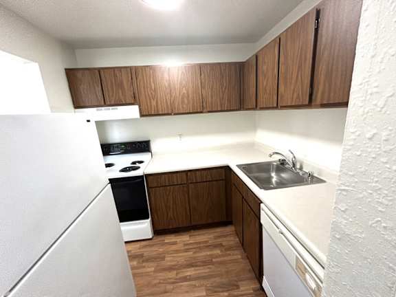 A kitchen with wooden cabinets and a white refrigerator.