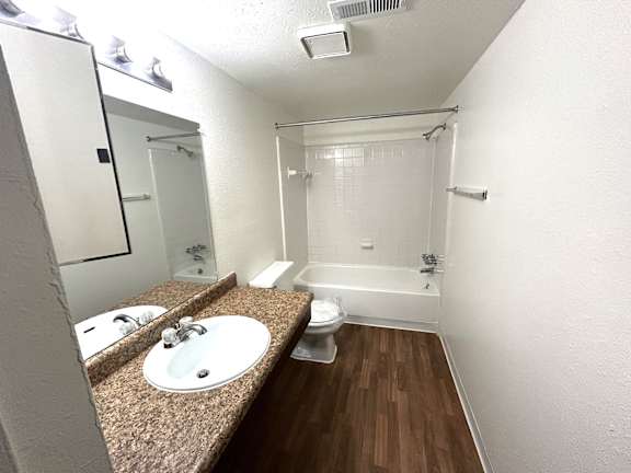 A bathroom with a sink, toilet, and shower.