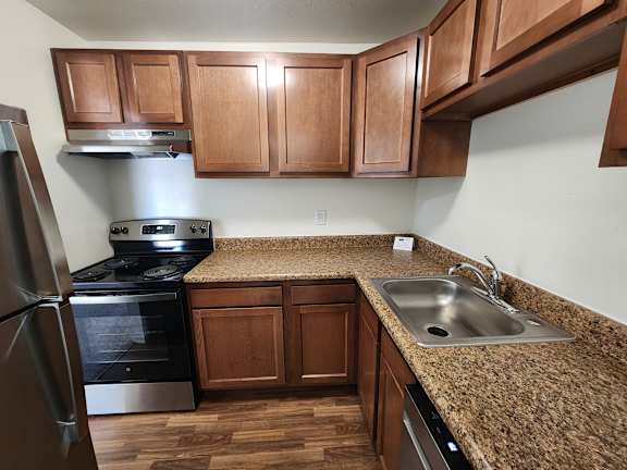 A kitchen with wooden cabinets and granite countertops.