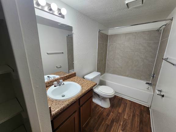 A bathroom with a sink, toilet, and shower.