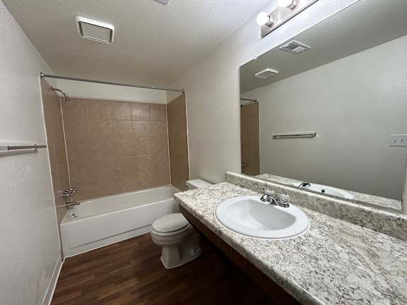 A bathroom with a sink, toilet, and bathtub.